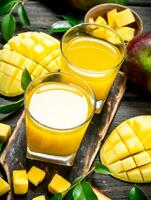 Mango juice and slices of fresh mango on the cutting Board. photo