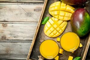 mango jugo en un vaso en bandeja. foto