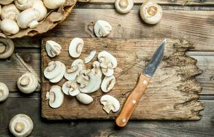 Cut mushrooms on a cutting Board with a knife. photo