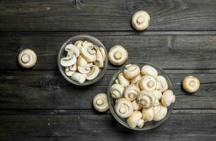 Sliced and whole mushrooms in bowl. photo