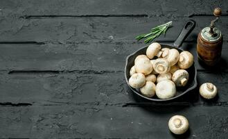 Mushrooms in pan and pepper grinder. photo