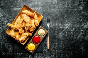 Chicken strips with different sauces and fork. photo