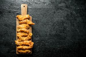 Chicken strips on a wooden cutting Board. photo