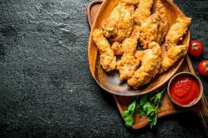 pollo tiras en un plato con perejil y salsa. foto