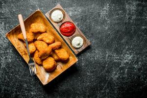 Chicken nuggets with different sauces. photo