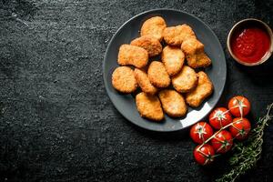 Chicken nuggets with sauce, thyme and cherry tomatoes. photo