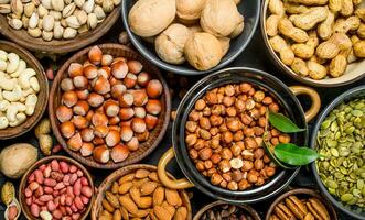 Assortment of different nuts in bowls. photo