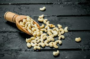 Cashew nuts in a wooden scoop . photo