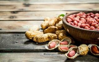The shelled peanuts in a bowl . photo