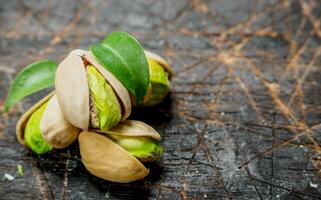 Pistachios with green leaves . photo