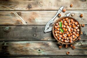 Hazelnuts in a bowl with a Nutcracker. photo