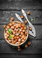 Hazelnuts in a bowl with a Nutcracker. photo