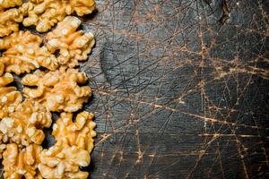 Peeled walnut on wooden background. photo