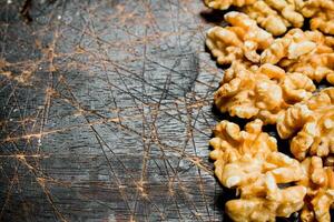 Peeled walnut on wooden background. photo