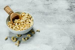 Cashews in a bowl with a scoop . photo