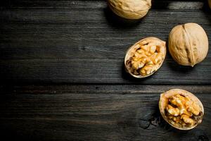 Peeled walnut on wooden background. photo