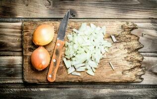 Finely chopped onion on a cutting Board with a knife. photo