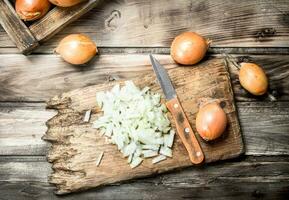 Finely chopped onion on a cutting Board with a knife. photo