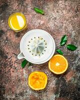 Orange juice in a glass and a juicer. photo