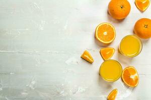 Orange juice in a glass and slices of fresh oranges. photo