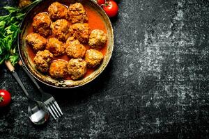Meat balls with herbs and tomatoes. photo