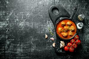 Meat balls in pan with tomatoes and garlic. photo