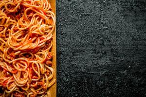 Pasta with Bolognese sauce in wooden plate. photo