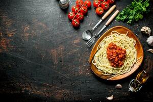 Spaghetti with Bolognese sauce in a plate with tomatoes, parsley and garlic. photo