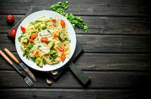 Pasta with vegetables and sauce on a plate. photo
