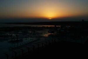 calma puesta de sol en trusia con puntos de vista de el playa y nadando quinielas foto