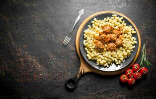 Pasta with meat balls and tomatoes on a branch. photo