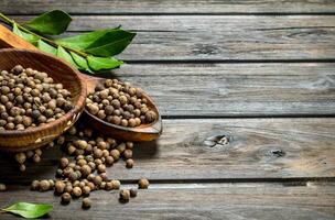 Black pepper peas in bowl with spoon and Bay leaves. photo