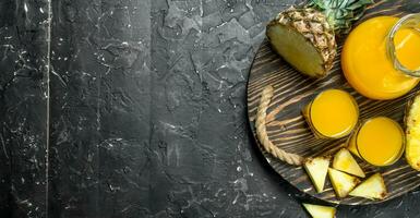 Pineapple juice in glass and jug on tray. photo