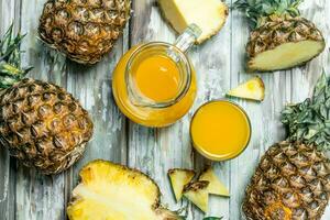 Pineapple juice in a glass and jug. photo