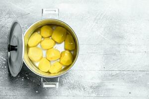 Peeled potatoes in a pot. photo