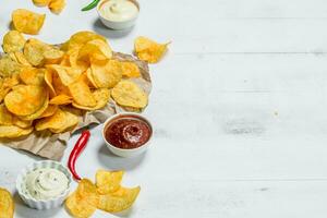 Potato chips with different sauces. photo