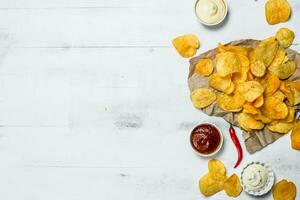 Potato chips with different sauces. photo