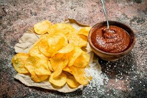 Potato chips with tomato sauce and salt. photo