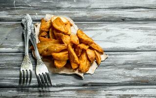 Baked potato wedges on the paper. photo