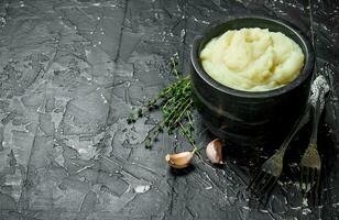 Mashed potatoes in a bowl with garlic and thyme. photo