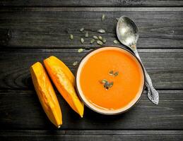 Pumpkin soup in bowl with spoon. photo