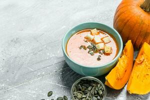 Pumpkin soup with slices of ripe pumpkin and seeds. photo