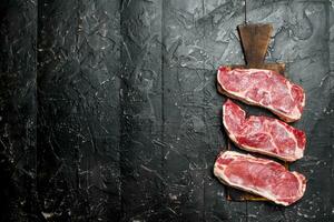 Raw beef steaks on cutting Board. photo