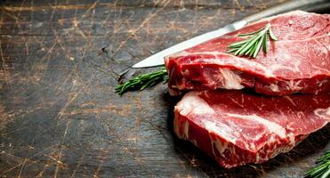 Raw marbled beef steaks with rosemary. photo