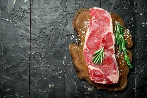 Raw beef steaks with fragrant rosemary. photo