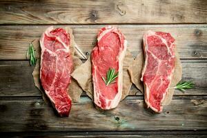 Raw marbled beef steaks with rosemary. photo