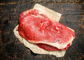 Raw steak of juicy beef on paper. photo