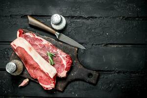 Raw beef steaks with spices and salt. photo