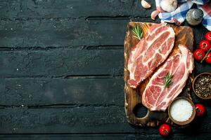 Raw pork steaks with aromatic and herbs and spices. photo