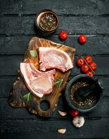 Raw pork steak on the bone with spices. photo